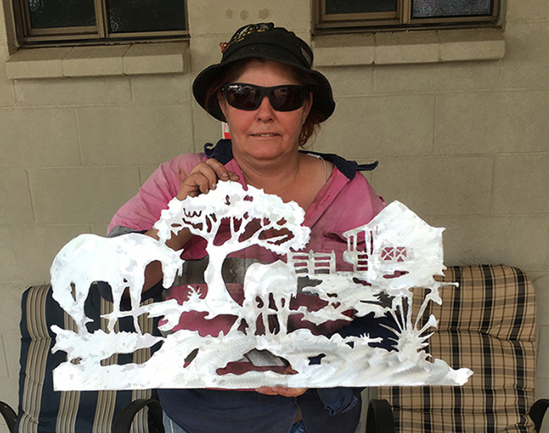 TRACQS CDP participant Tammy with her metal garden art she created through our activity group.