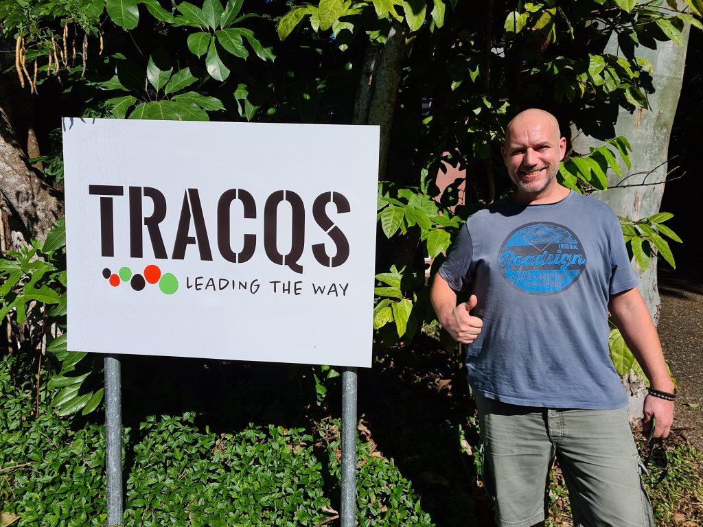 TRACQS CDP participant Stephan standing next to a TRACQS sign