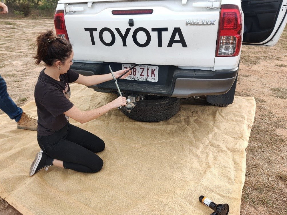 TRACQS staff member learning to change tyre as a part of 4WD training 
