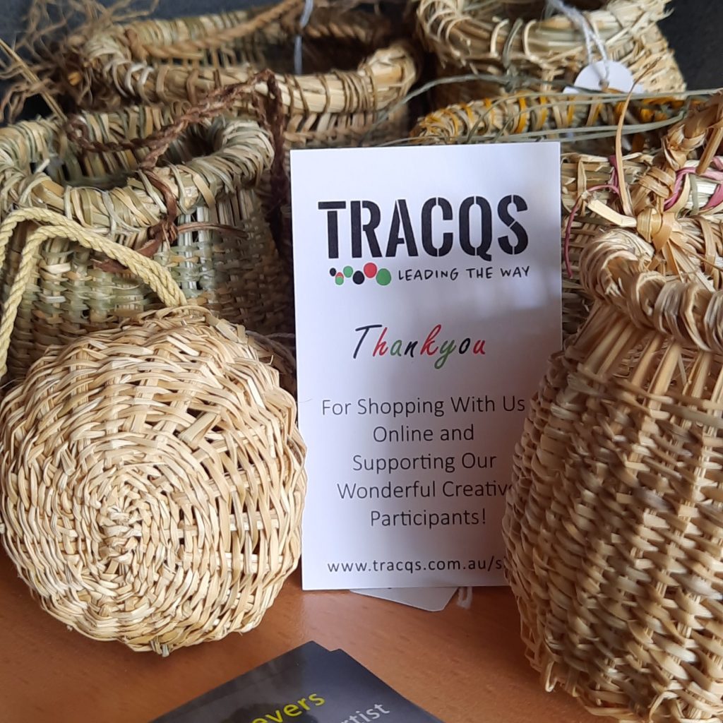 TRACQS thank you card standing up alongside some handmade weaved baskets 